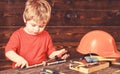 Toddler on busy face plays with screwdriver tool at home in workshop. Childhood concept. Child cute and adorable playing