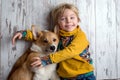 Toddler child and dog, boy and puppy playing together at home Royalty Free Stock Photo