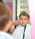 Toddler child getting his first haircut at salon