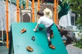 Toddler child having fun trying to climb on artificial boulders Royalty Free Stock Photo