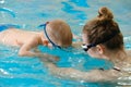 Toddler child trained to dive in indoor swimming pool