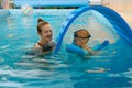 Toddler child trained to swim in indoor swimming pool