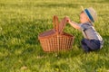 Toddler child outdoors. One year old baby boy wearing straw hat looking in picnic basket Royalty Free Stock Photo