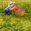 Toddler child outdoors. One year old baby boy wearing straw hat looking in picnic basket Royalty Free Stock Photo