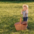 Toddler child outdoors. One year old baby boy wearing straw hat with picnic basket Royalty Free Stock Photo