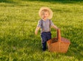 Toddler child outdoors. One year old baby boy wearing straw hat with picnic basket Royalty Free Stock Photo