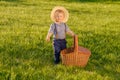 Toddler child outdoors. One year old baby boy wearing straw hat with picnic basket Royalty Free Stock Photo