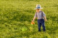 Toddler child outdoors. One year old baby boy wearing straw hat using watering can Royalty Free Stock Photo