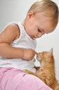 Toddler child plays with a cat