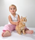 Toddler child plays with a cat Royalty Free Stock Photo