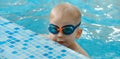 Toddler child trained to dive in indoor swimming pool