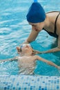 Toddler child trained to swim in indoor swimming pool