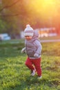 Toddler child in warm vest jacket outdoors. Baby boy at park during sunset. Royalty Free Stock Photo