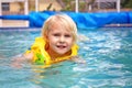 Toddler Child Wearing Inflatable Life Jacket Learning to Swim in Backyard Family Pool Royalty Free Stock Photo