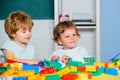 Toddler children play with blocks, trains and cars. Educational toys for preschool and kindergarten child. Royalty Free Stock Photo