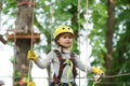 Toddler climbing in a rope playground structure. Cargo net climbing and hanging log. Kids boy adventure and travel. Eco