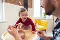 Toddler cute baby girl crying and don& x27;t want to eat food from her father. Royalty Free Stock Photo