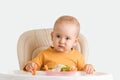 Toddler does not like vegetarian food, the child sitting on a feeding chair refuses to eat boiled vegetables Royalty Free Stock Photo