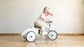 Toddler driving beige retro car. Happy small boy sitting on vintage toy car. Kid playing in nursery room. Happy child Royalty Free Stock Photo