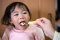 A toddler eating natto - a Japanese fermented soy beans. Healthy food. Hand feeding Royalty Free Stock Photo