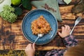 Toddler eating vegetable ragout. Outdoor dining, table top view.