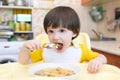 Toddler eats soup with meat balls at home kitchen Royalty Free Stock Photo