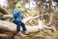 Toddler Enjoying a Drink Outdoors on a Fallen Tree