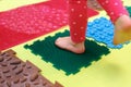 Toddler with a flat-bottomed stomach goes barefoot on an orthopedic foot mat for the appointment of an orthopedist. gymnastics for