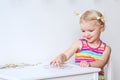 Toddler girl assembling jigsaw puzzle indoors