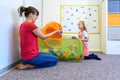 Toddler girl in child occupational therapy session doing playful exercises with her therapist.