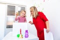 Toddler girl in child occupational therapy session doing sensory playful exercises with her therapist. Royalty Free Stock Photo