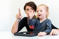 Toddler girl in child occupational therapy session doing sensory playful exercises with her therapist.