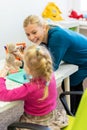 Toddler girl in child occupational therapy session doing sensory playful exercises with her therapist.