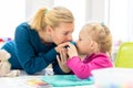 Toddler girl in child occupational therapy session doing sensory playful exercises with her therapist. Royalty Free Stock Photo