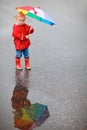 Toddler girl with colorful umbrella on rainy day