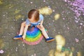 Toddler girl drawing rainbow with colorful chalks Royalty Free Stock Photo