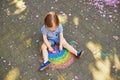 Toddler girl drawing rainbow with colorful chalks Royalty Free Stock Photo