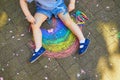 Toddler girl drawing rainbow with colorful chalks Royalty Free Stock Photo