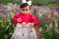 toddler girl enjoying Angelonia flower blooming