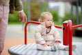 Toddler girl having fun on outdoor playground. Young father rides daughter on carousel. Spring/summer/autumn active leisure for Royalty Free Stock Photo