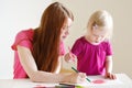 Toddler girl and her mom drawing with pencils Royalty Free Stock Photo