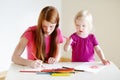 Toddler girl and her mom drawing with pencils Royalty Free Stock Photo