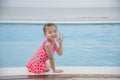 Toddler girl Kid swim playful in swimming pool summer time with pink swimwear in blue water at hotel swimming pool outdoor. Happy Royalty Free Stock Photo