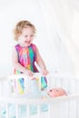 Toddler girl next to white round bed of her brother Royalty Free Stock Photo