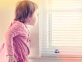 Toddler girl peeking out of the window Royalty Free Stock Photo