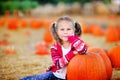 Toddler girl picking a pumpkin for Halloween