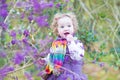 Toddler girl picking purple berries in autumn park Royalty Free Stock Photo