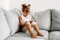 Toddler girl playing with digital wireless tablet computer on couch at home. Baby child growing with online applications.