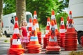 Toddler girl playing with many safety traffic cones on the street Royalty Free Stock Photo