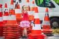 Toddler girl playing with many safety traffic cones on the street Royalty Free Stock Photo